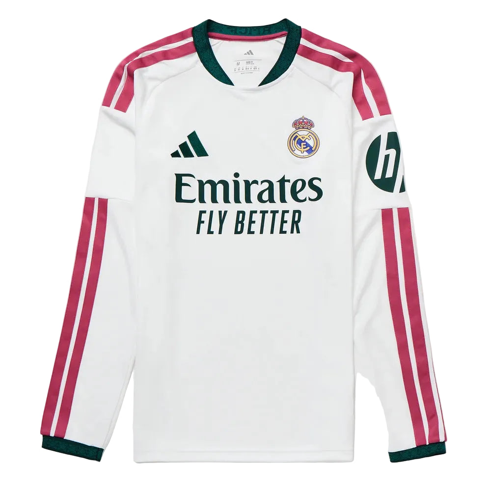 A white long-sleeve Real Madrid soccer jersey by Adidas, featuring dark green trim on the collar and cuffs, pink and white stripes on the sleeves, the Adidas logo on the right chest, the Real Madrid crest on the left chest, and the Emirates Fly Better sponsor logo across the center.
