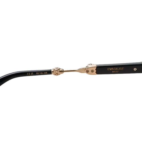 Close-up of the hinge and inner temple arms of a pair of black sunglasses with ornate gold-tone detailing, including the brand name EVAGUILIST and model BRID.