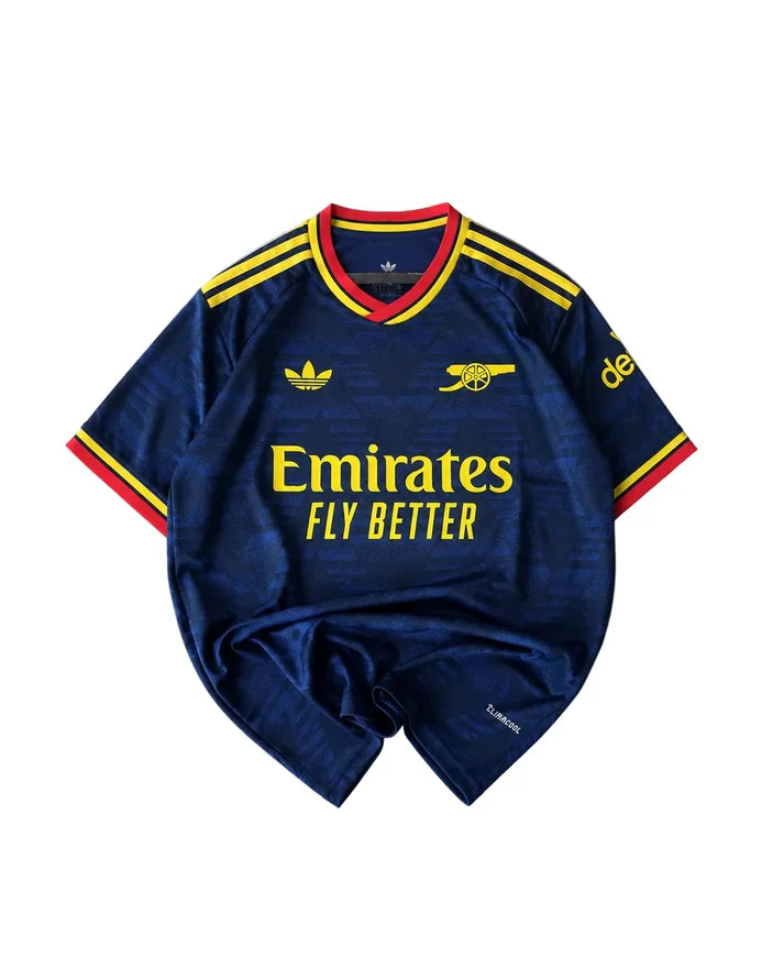 A navy blue Arsenal football jersey with yellow and red accents, featuring the Adidas logo, Arsenal cannon crest, and Emirates Fly Better sponsor text, laid flat on a white background.