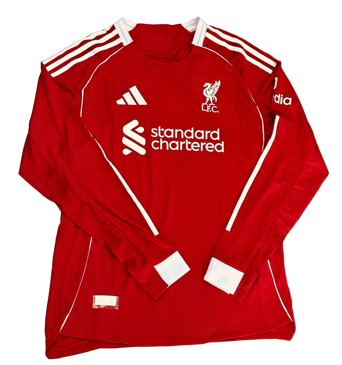 Red sports jersey with white accents and branding on a tiled floor.