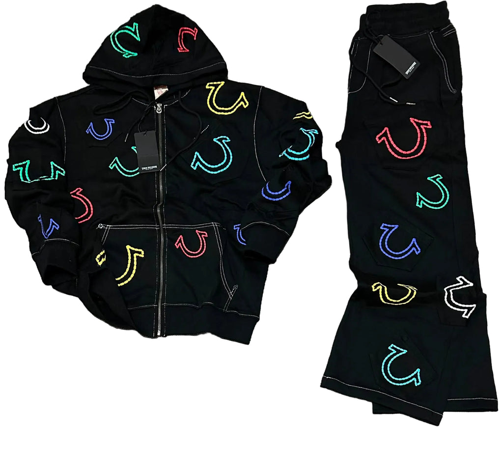 A black zip-up hoodie and matching black pants laid flat on a gray textured surface. Both pieces feature colorful embroidered horseshoe motifs in multiple neon-like colors including green, blue, red, yellow, and white.
