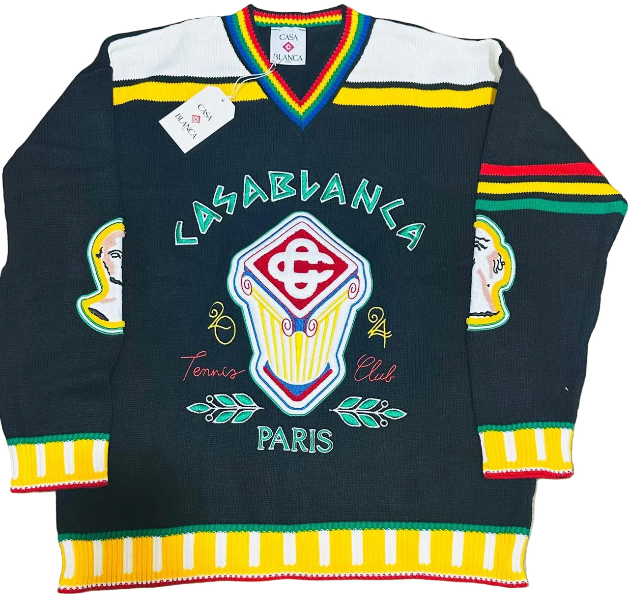 A vintage knit hockey-style sweater with 'LASABLANCA Tennis Club PARIS' text and a large central crest, laid flat on a beige faux-fur surface. The sweater is black with white shoulder panels, multicolor striped trim, and colorful graphic details.
