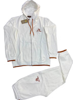 A white two-piece tracksuit set consisting of a zip-up hoodie and matching sweatpants, laid flat on a dark gray textured surface. The tracksuit features brown drawstrings, brown ribbed trim on the cuffs and hem, and a small embroidered logo on the left chest and left thigh.