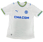A white Inter Milan soccer jersey by Puma with blue and yellow trim, laid flat on a green grass-like surface. The jersey features the Inter Milan club crest and the sponsor logo CMA CGM.