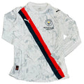White sports jersey with red and blue stripes on a beige background